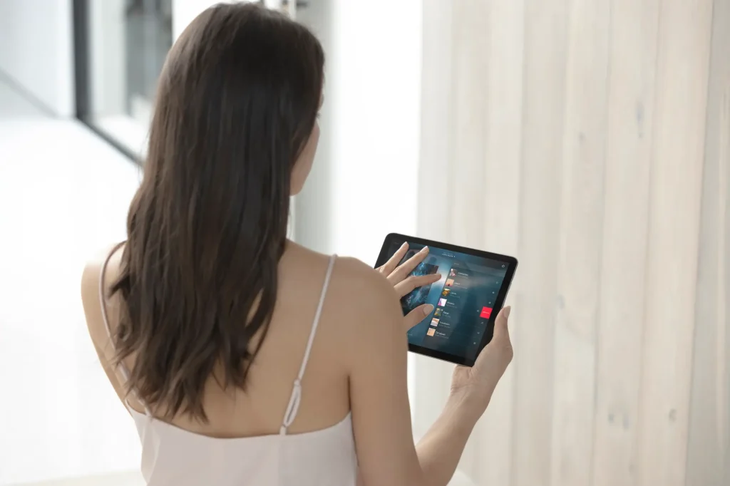 Woman controlling her smart home with the Savant app on an iPad
