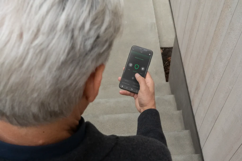 Homeowner viewing a security camera feed in the Savant app on a smartphone