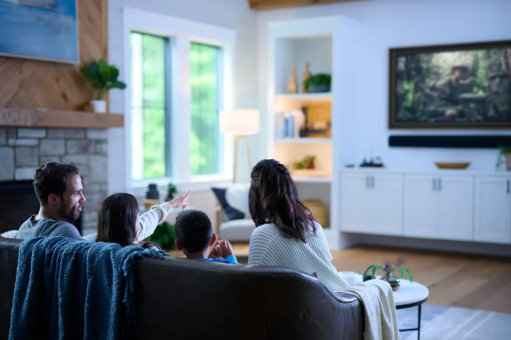 Family watching a movie with Savant home theater and lighting control